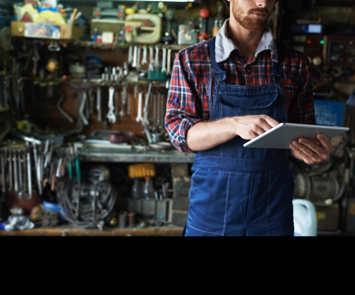 Technician in an equipment workshop using a tablet app